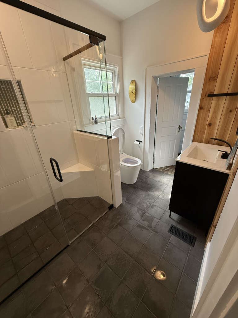 Finished Clayton NC bathroom renovation with dark flooring and black accents