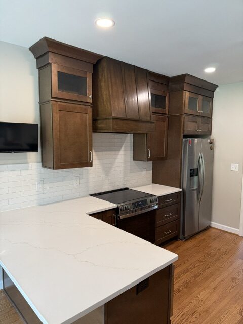 Completed kitchen remodeling Clayton NC project with dark wood cabinets and white countertops